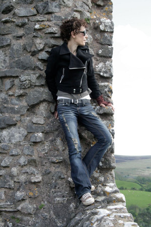 Helen leaning by Carreg Cennen Castle pensively